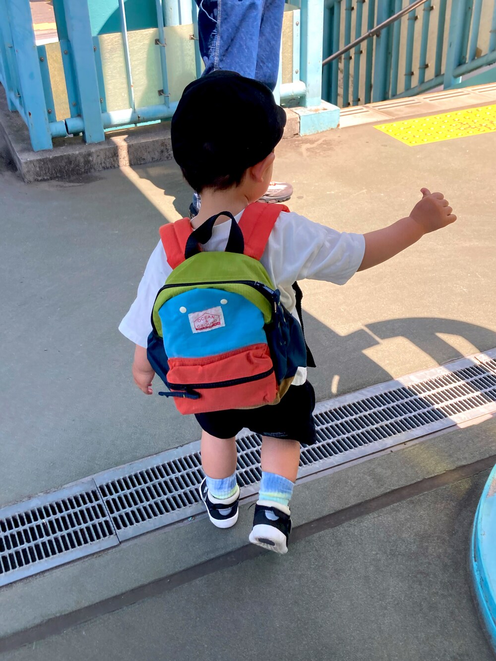 ホワイト系のTシャツ/カットソー、ブラック系のパンツ、ブラック系のキャップを着用したキッズの春コーディネートの2枚目の写真