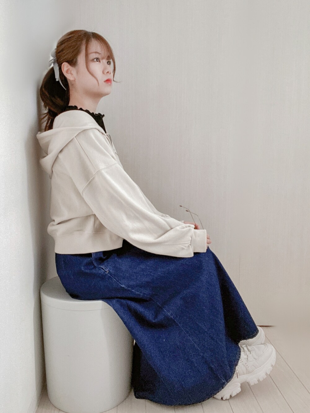 ホワイト系のパーカー、ブラック系のTシャツ/カットソー、ブルー系のデニムスカートを着用したレディースの春コーディネートの2枚目の写真