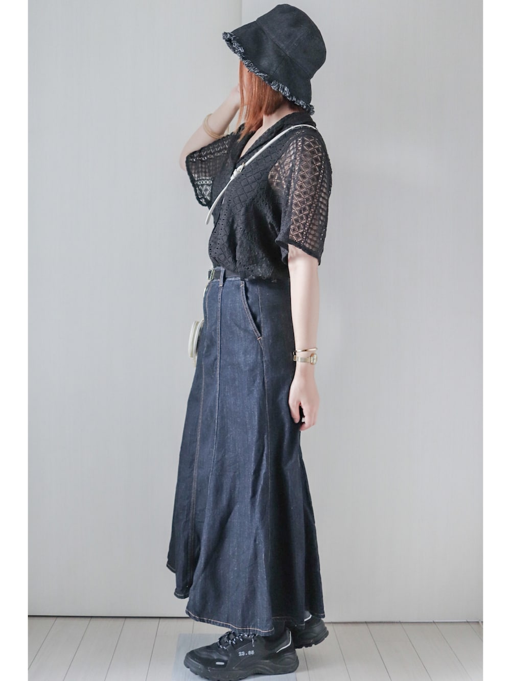 ブラック系のシャツ/ブラウス、ブルー系のデニムスカート、ブラック系のスニーカーを着用したレディースの夏コーディネートの2枚目の写真