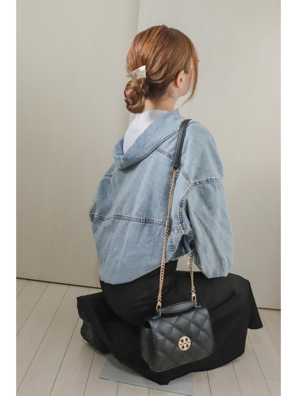 グレー系のTシャツ/カットソー、ブルー系のデニムジャケット、ブラック系のスカートを着用したレディースの春コーディネートの2枚目の写真