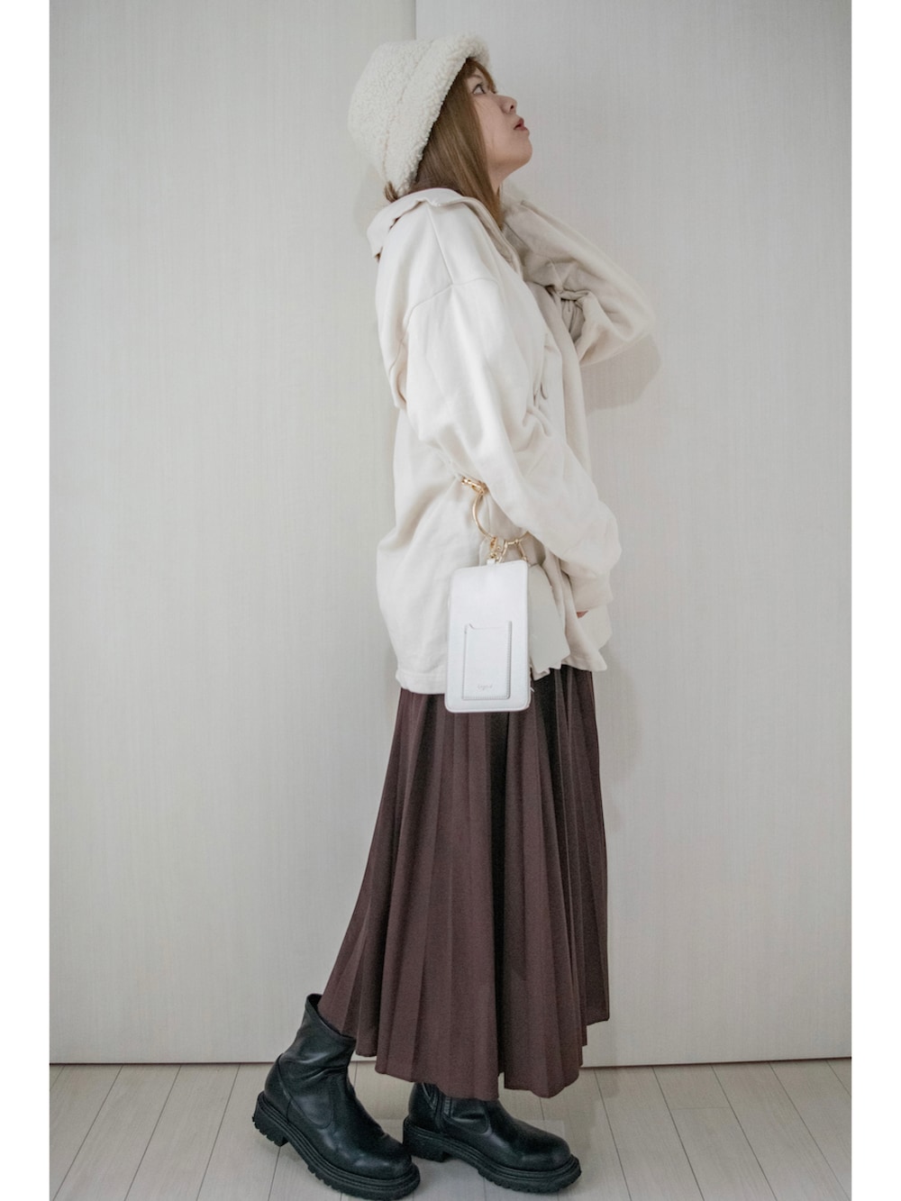ホワイト系のスウェット、ベージュ系のTシャツ/カットソー、ブラウン系のスカートを着用したレディースの秋コーディネートの2枚目の写真