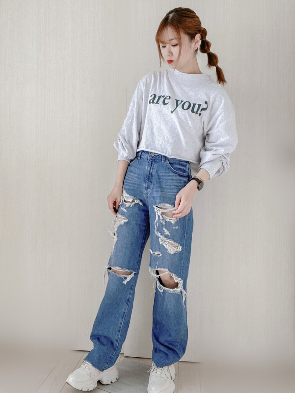 グレー系のTシャツ/カットソー、ブルー系のデニムパンツ、ベージュ系のスニーカーを着用したレディースの春コーディネートの2枚目の写真