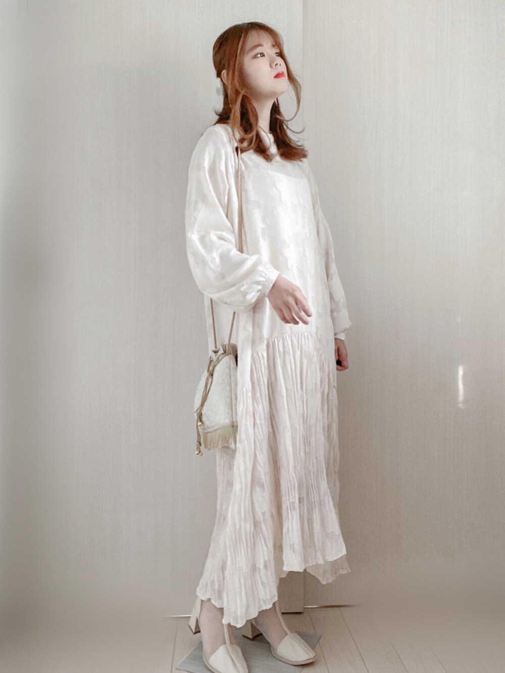 ホワイト系のワンピース、ベージュ系のショルダーバッグ、ホワイト系のブーツを着用したレディースの春コーディネートの2枚目の写真