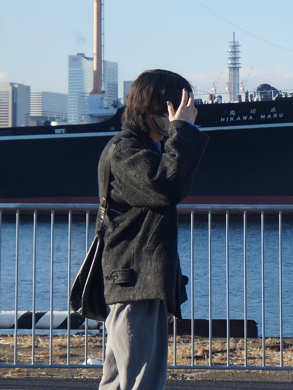 グレー系のブルゾン、ブルー系のニット/セーター、グレー系のセットアップを着用したメンズの冬コーディネートの2枚目の写真