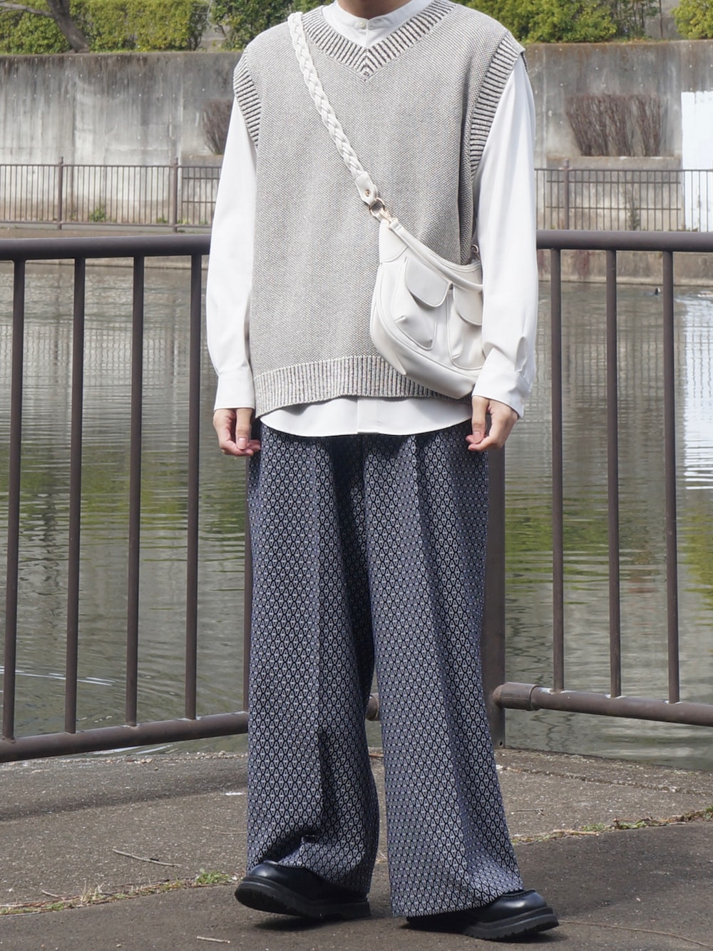 ブラック系のブルゾン、ホワイト系のシャツ/ブラウス、ホワイト系のスラックスを着用したメンズの春コーディネートの2枚目の写真