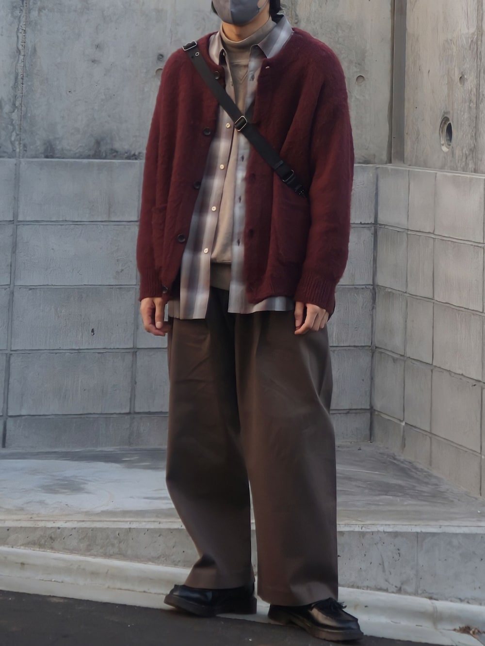 レッド系のカーディガン/ボレロ、ブラウン系のシャツ/ブラウス、ベージュ系のニット/セーターを着用したメンズの秋コーディネートの2枚目の写真