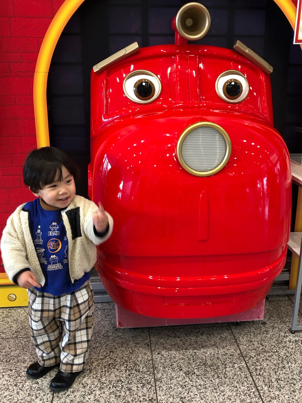 ホワイト系のその他アウター、ブルー系のスウェット、イエロー系のニット/セーターを着用したキッズの冬コーディネートの2枚目の写真