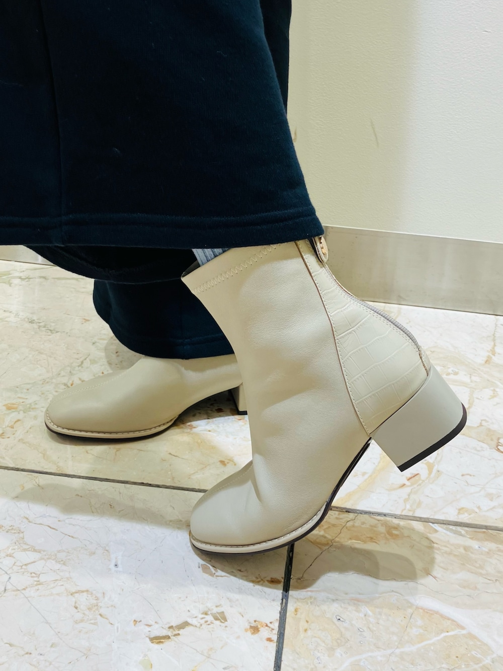 ホワイト系のブーツを着用したレディースの秋コーディネートの2枚目の写真