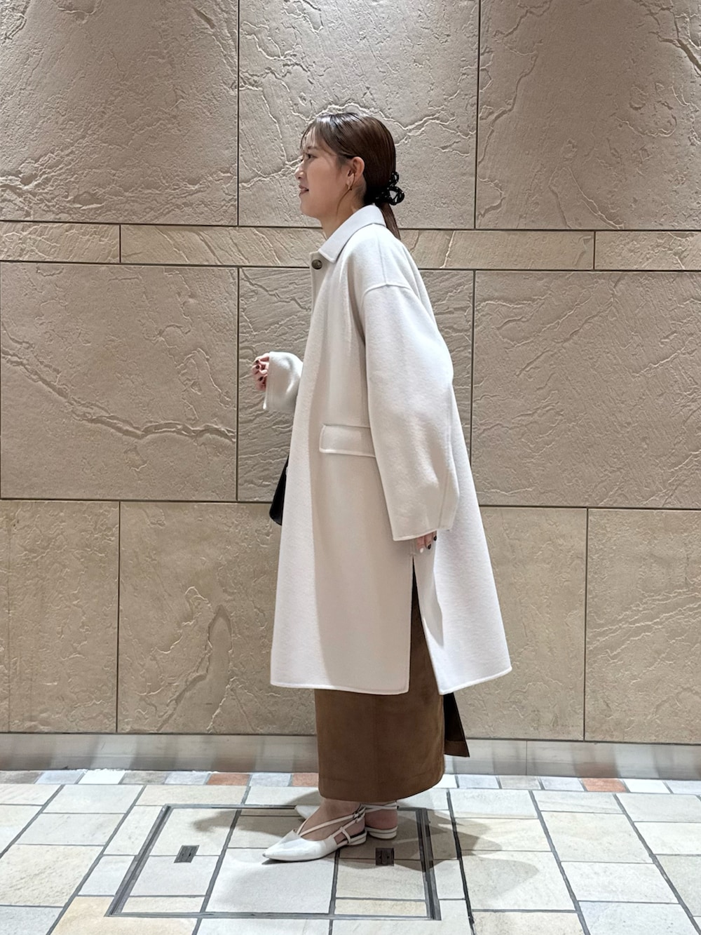 イエロー系のカーディガン/ボレロ、ホワイト系のシャツ/ブラウス、イエロー系のスカートを着用したレディースの秋コーディネートの5枚目の写真