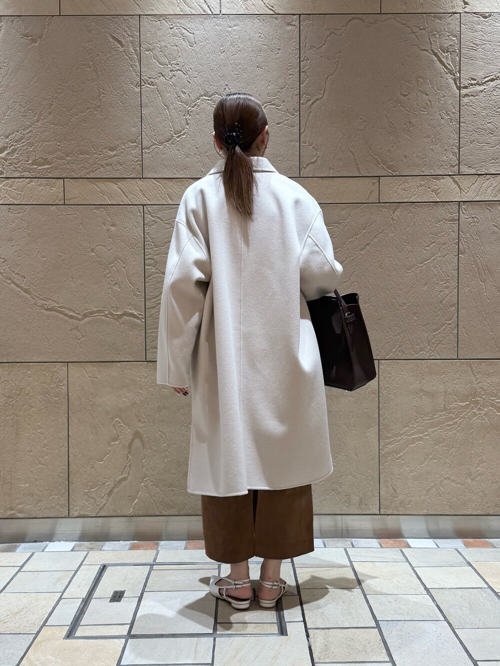 イエロー系のカーディガン/ボレロ、ホワイト系のシャツ/ブラウス、イエロー系のスカートを着用したレディースの秋コーディネートの3枚目の写真