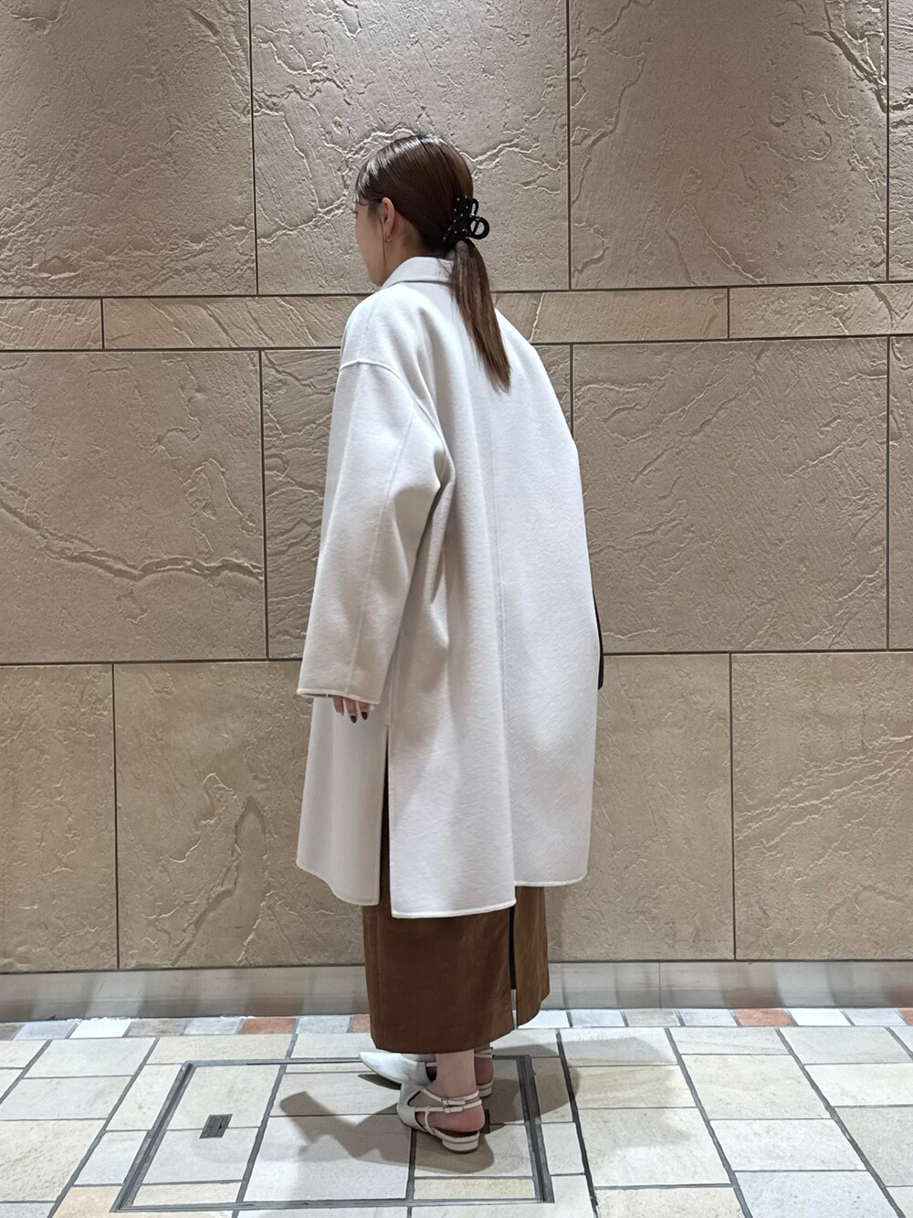 イエロー系のカーディガン/ボレロ、ホワイト系のシャツ/ブラウス、イエロー系のスカートを着用したレディースの秋コーディネートの4枚目の写真