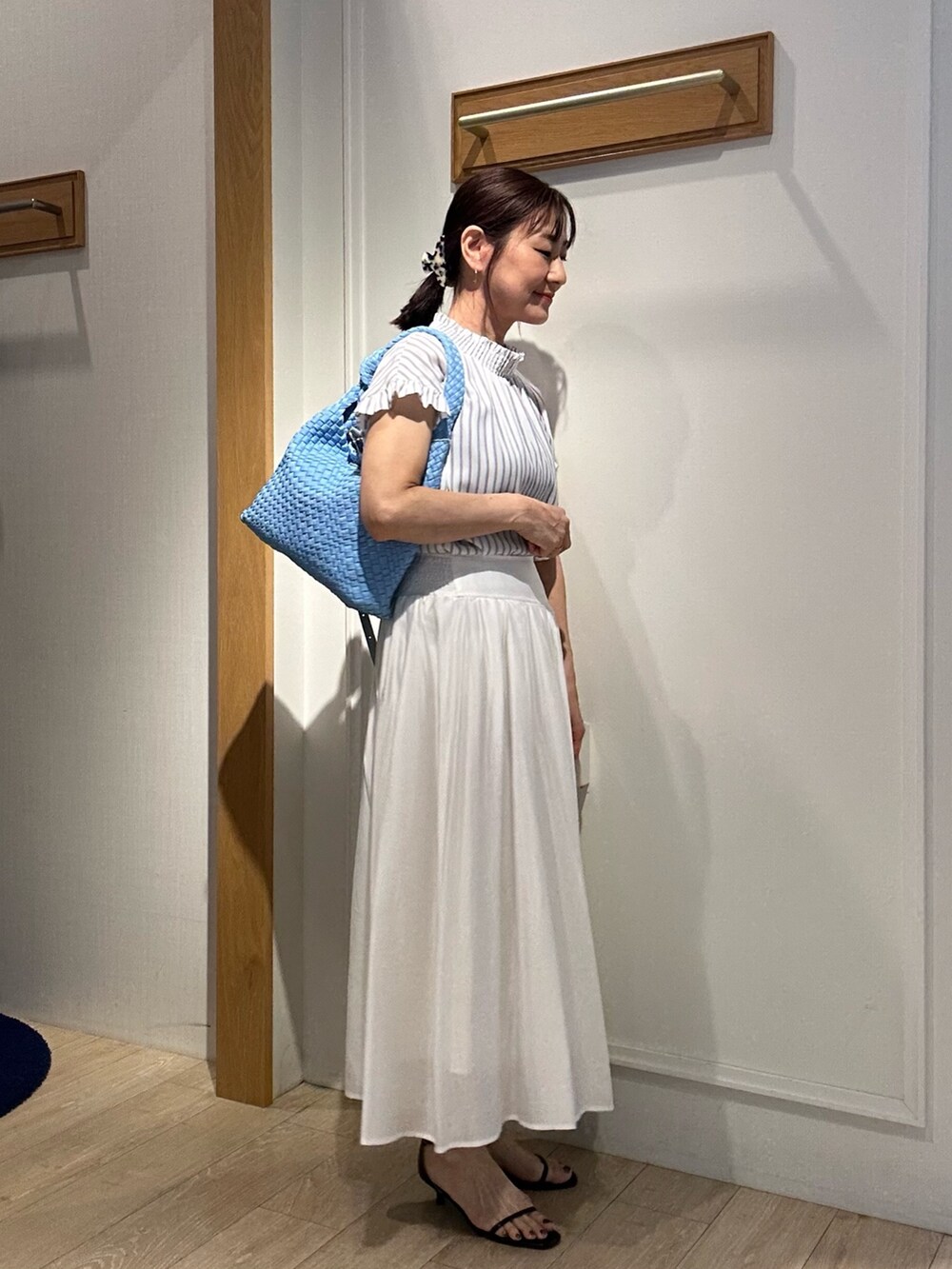 ホワイト系のシャツ/ブラウス、ホワイト系のスカート、ブルー系のショルダーバッグを着用したレディースの春コーディネートの2枚目の写真