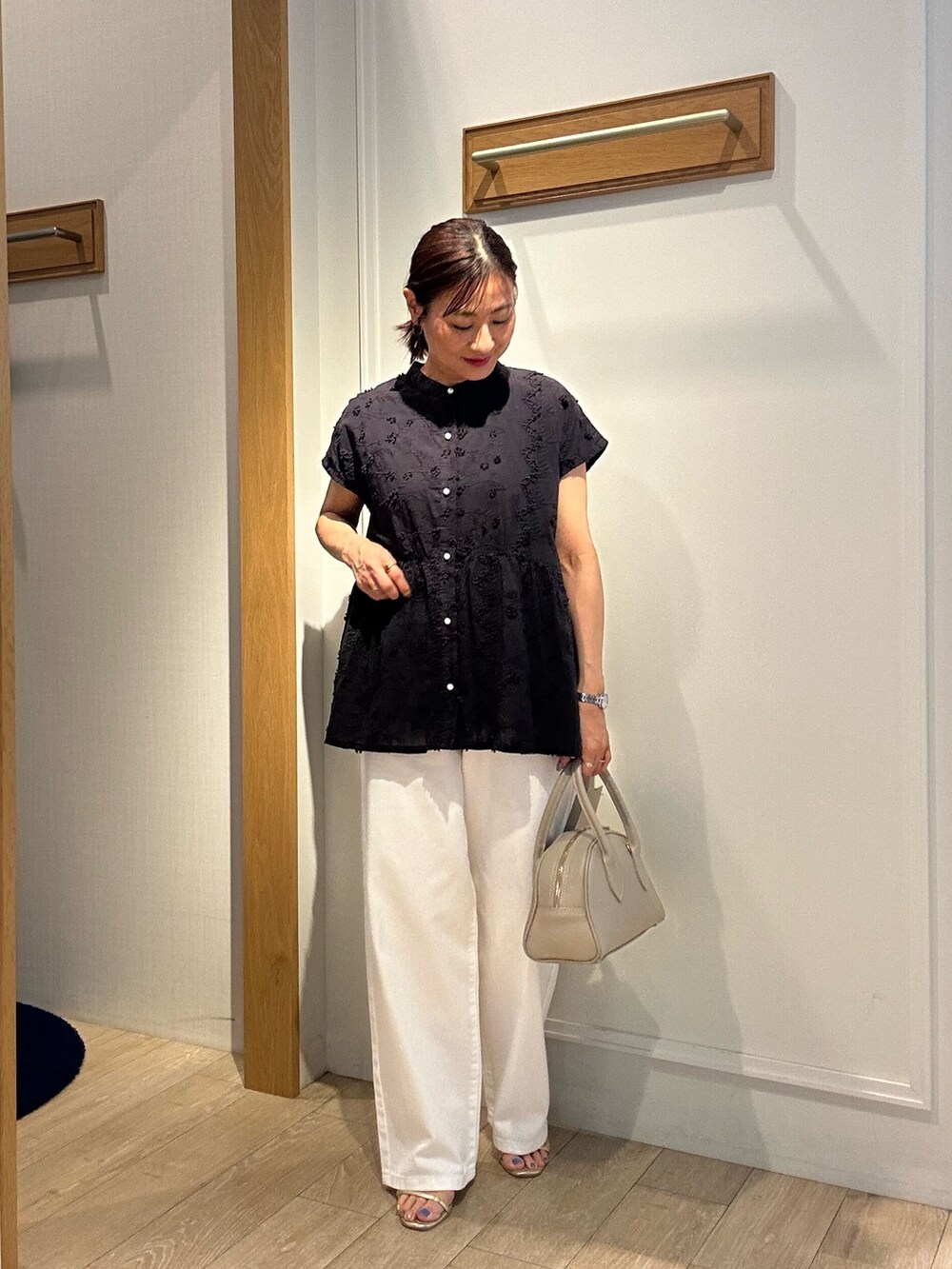 ブラック系のシャツ/ブラウス、ホワイト系のデニムパンツ、ベージュ系のボストンバッグを着用したレディースの夏コーディネートの2枚目の写真