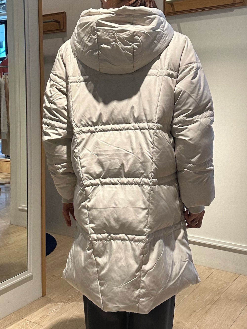 ベージュ系のダウンジャケット/コート、ブルー系のニット/セーターを着用したレディースの冬コーディネートの6枚目の写真