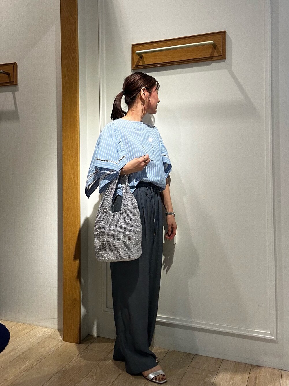 ブルー系のシャツ/ブラウス、ブルー系のデニムパンツ、シルバー系のトートバッグを着用したレディースの春コーディネートの4枚目の写真