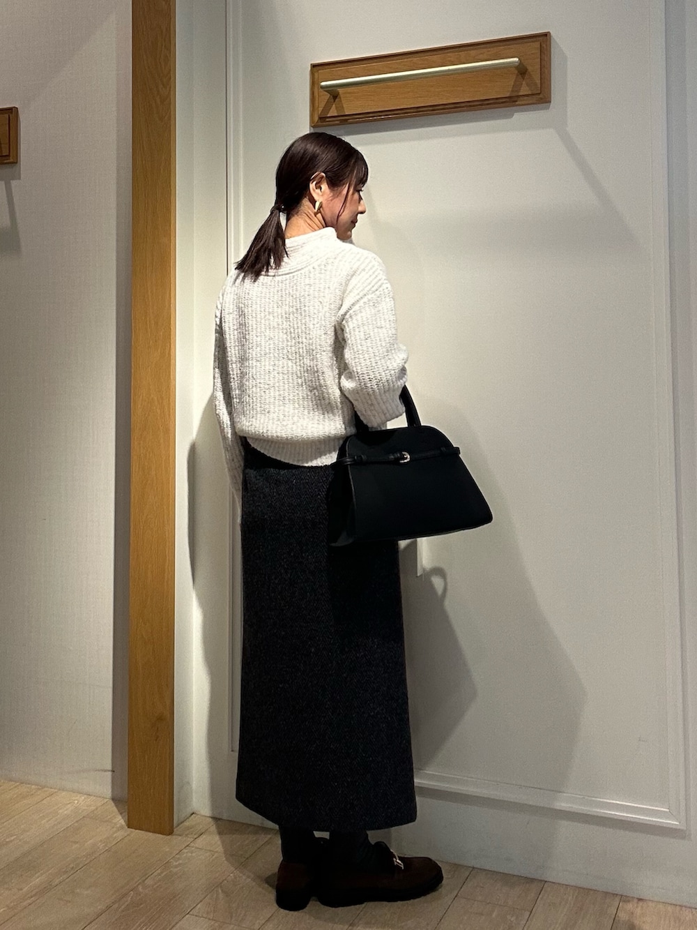 ブラック系のダウンジャケット/コート、グレー系のスカート、ブラック系のトートバッグを着用したレディースの冬コーディネートの8枚目の写真