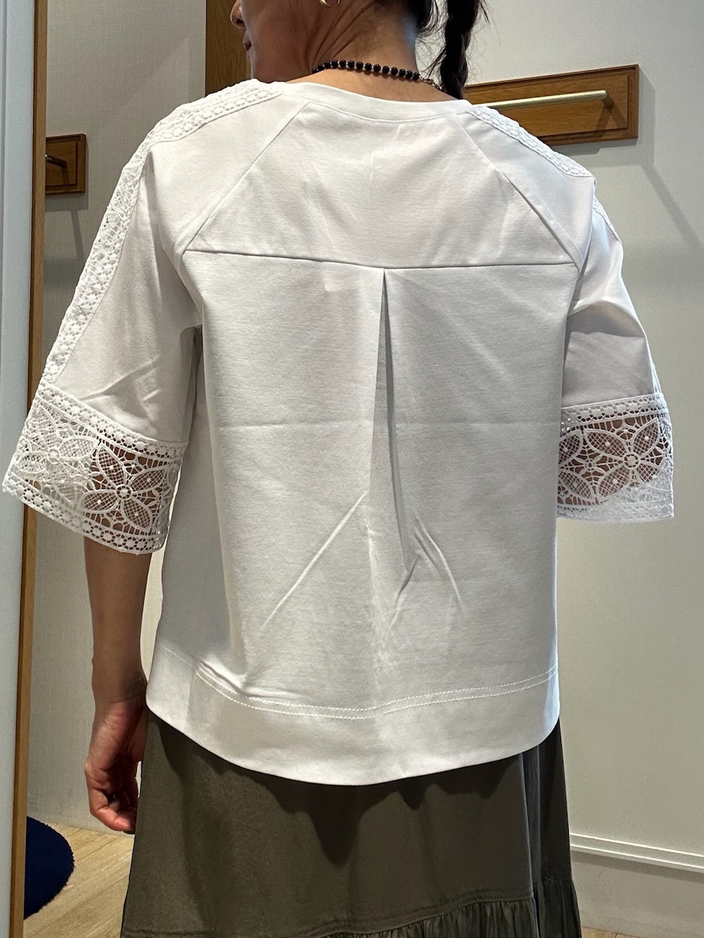 ホワイト系のTシャツ/カットソー、ブラック系のトートバッグ、グリーン系のスカートを着用したレディースの夏コーディネートの6枚目の写真