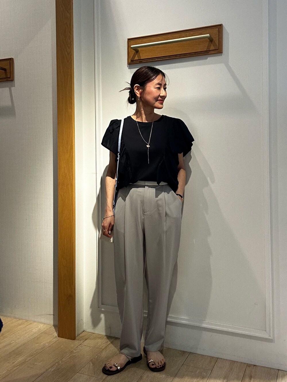 ブラック系のTシャツ/カットソー、ベージュ系のその他パンツ、ブルー系のショルダーバッグを着用したレディースの夏コーディネートの6枚目の写真