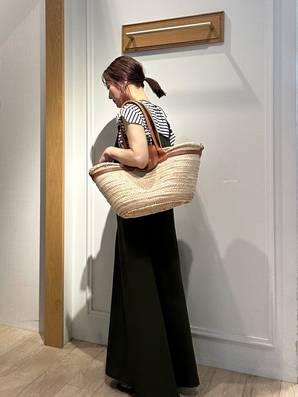 ブラック系のTシャツ/カットソー、グリーン系のワンピースを着用したレディースの夏コーディネートの2枚目の写真