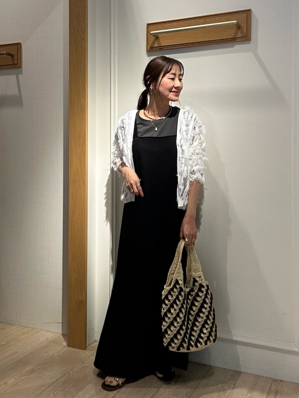 ホワイト系のカーディガン/ボレロ、ブラック系のワンピース、ゴールド系のネックレスを着用したレディースの夏コーディネートの4枚目の写真