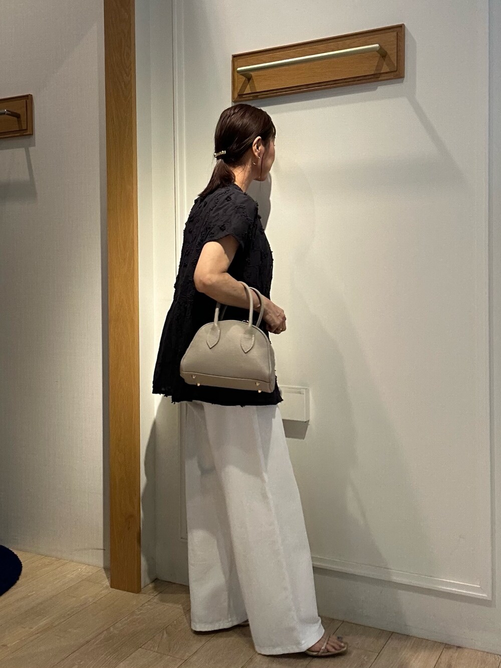 ブラック系のシャツ/ブラウス、ホワイト系のデニムパンツ、ベージュ系のボストンバッグを着用したレディースの夏コーディネートの5枚目の写真