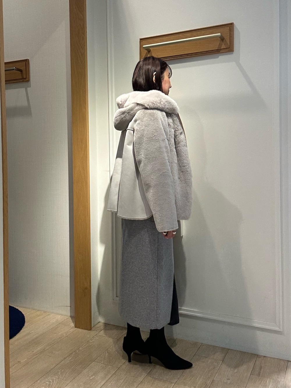 ベージュ系のムートンコート、ブルー系のニット/セーター、ホワイト系のニット/セーターを着用したレディースの冬コーディネートの3枚目の写真