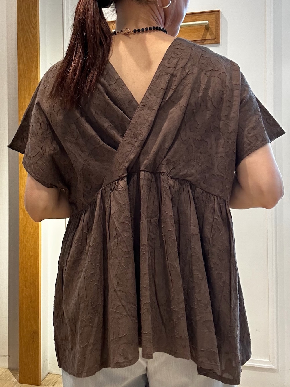 ブラウン系のシャツ/ブラウス、グレー系のその他パンツ、ゴールド系のトートバッグを着用したレディースの夏コーディネートの10枚目の写真