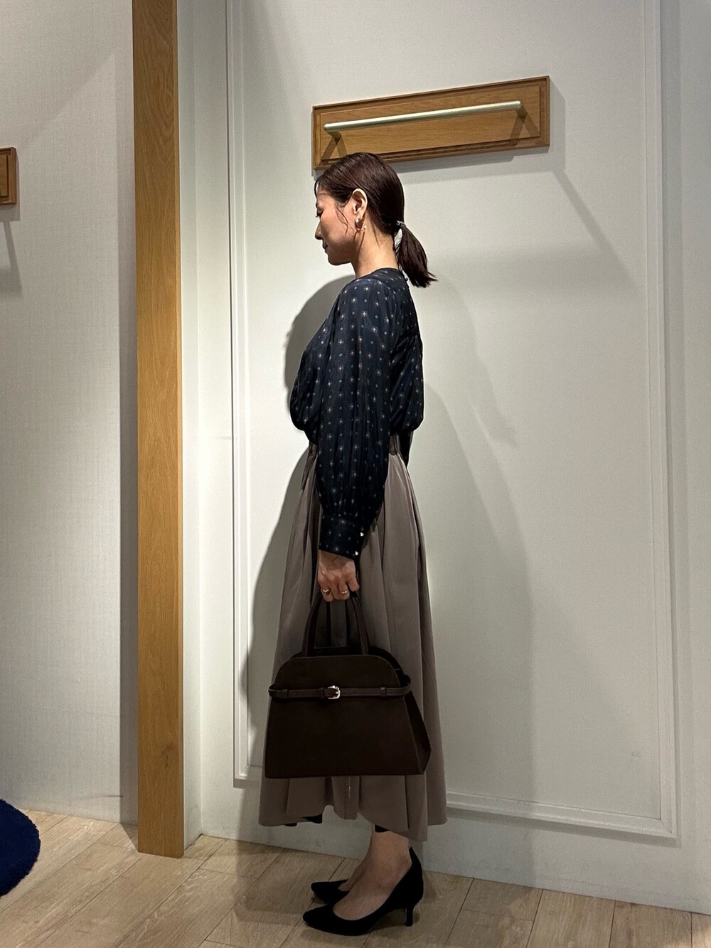 ブラウン系のスカート、ブルー系のシャツ/ブラウス、ブラウン系のトートバッグを着用したレディースの秋コーディネートの2枚目の写真