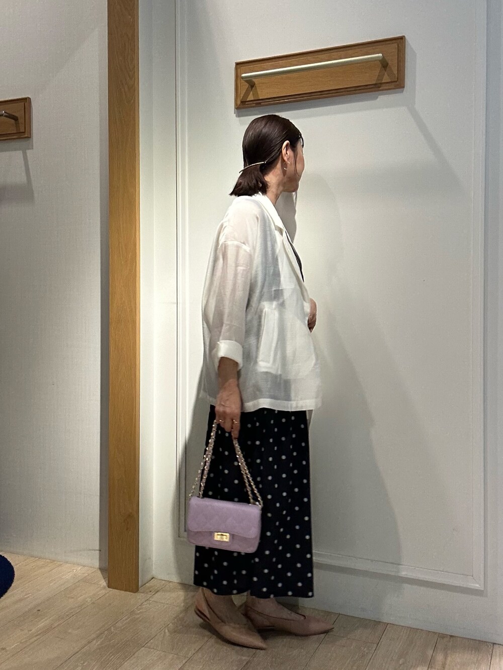 ホワイト系のテーラードジャケット、グレー系のTシャツ/カットソー、ブラック系のスカートを着用したレディースの春コーディネートの3枚目の写真