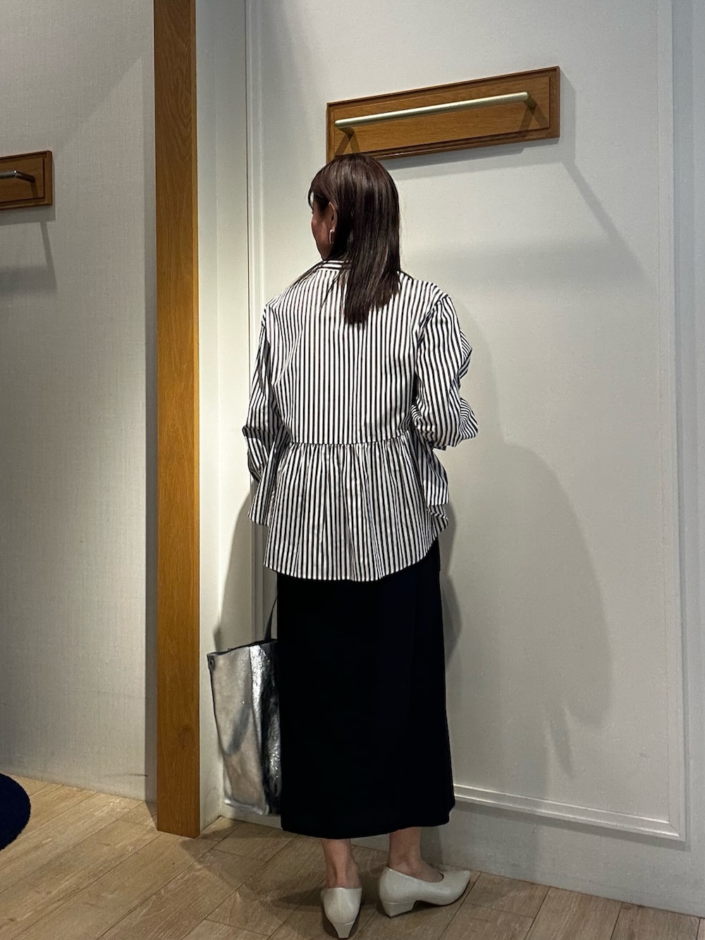 ブラック系のスカート、グレー系のシャツ/ブラウスを着用したレディースの春コーディネートの2枚目の写真