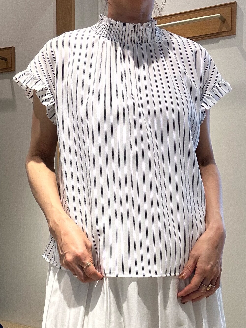 ホワイト系のシャツ/ブラウス、ホワイト系のスカート、ブルー系のショルダーバッグを着用したレディースの春コーディネートの5枚目の写真