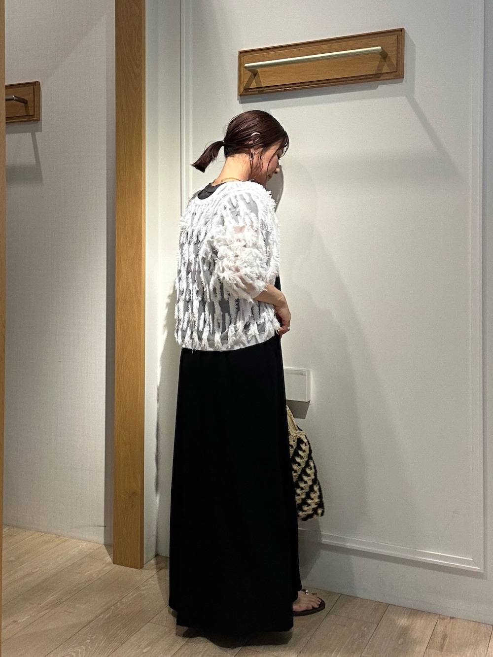 ホワイト系のカーディガン/ボレロ、ブラック系のワンピース、ゴールド系のネックレスを着用したレディースの夏コーディネートの6枚目の写真