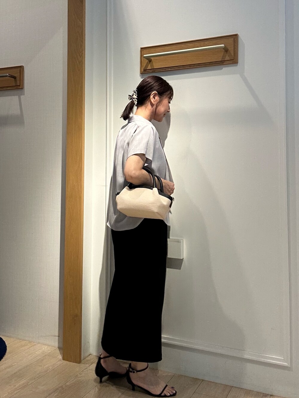 グレー系のシャツ/ブラウス、ブラック系のスカート、ブラック系のバックパック/リュックを着用したレディースの夏コーディネートの6枚目の写真