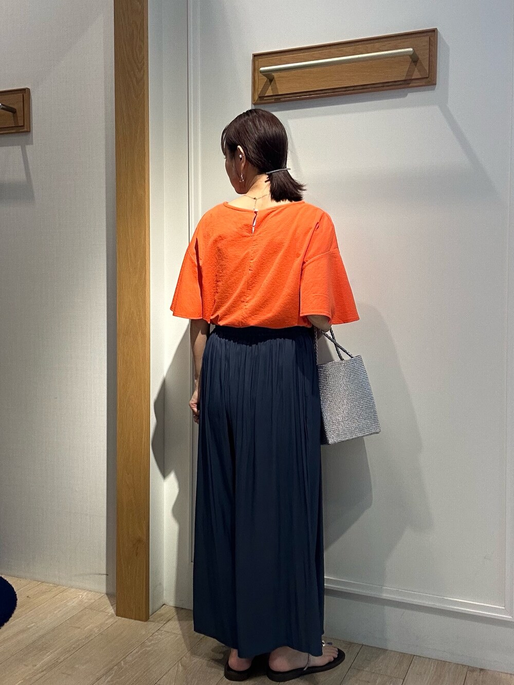 オレンジ系のTシャツ/カットソー、ブルー系のその他パンツを着用したレディースの夏コーディネートの3枚目の写真
