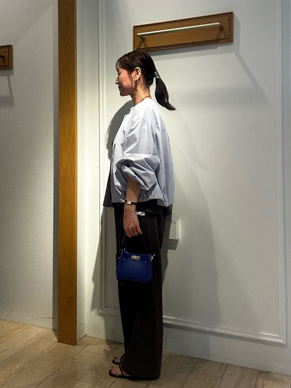 ブルー系のショルダーバッグ、ブルー系のブルゾン、グリーン系のシャツ/ブラウスを着用したレディースの春コーディネートの2枚目の写真