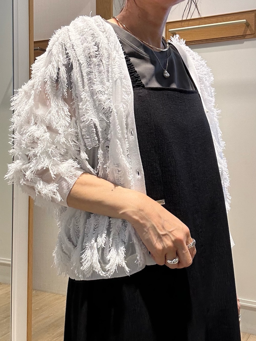 ホワイト系のカーディガン/ボレロ、ブラック系のワンピース、ゴールド系のネックレスを着用したレディースの夏コーディネートの7枚目の写真