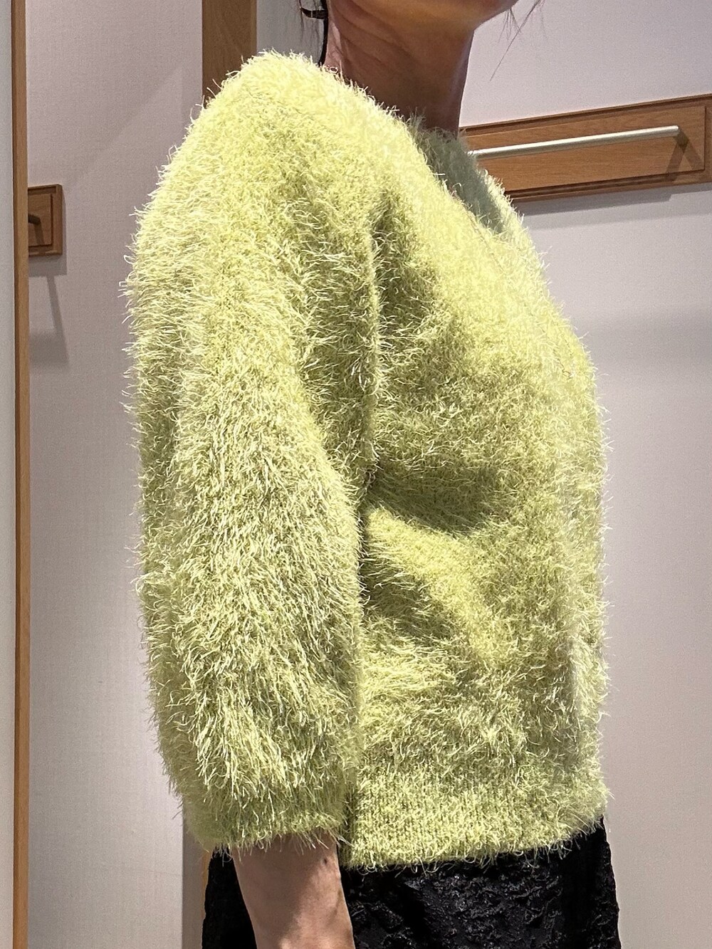 グリーン系のニット/セーター、グレー系のスカート、イエロー系のブルゾンを着用したレディースの秋コーディネートの6枚目の写真