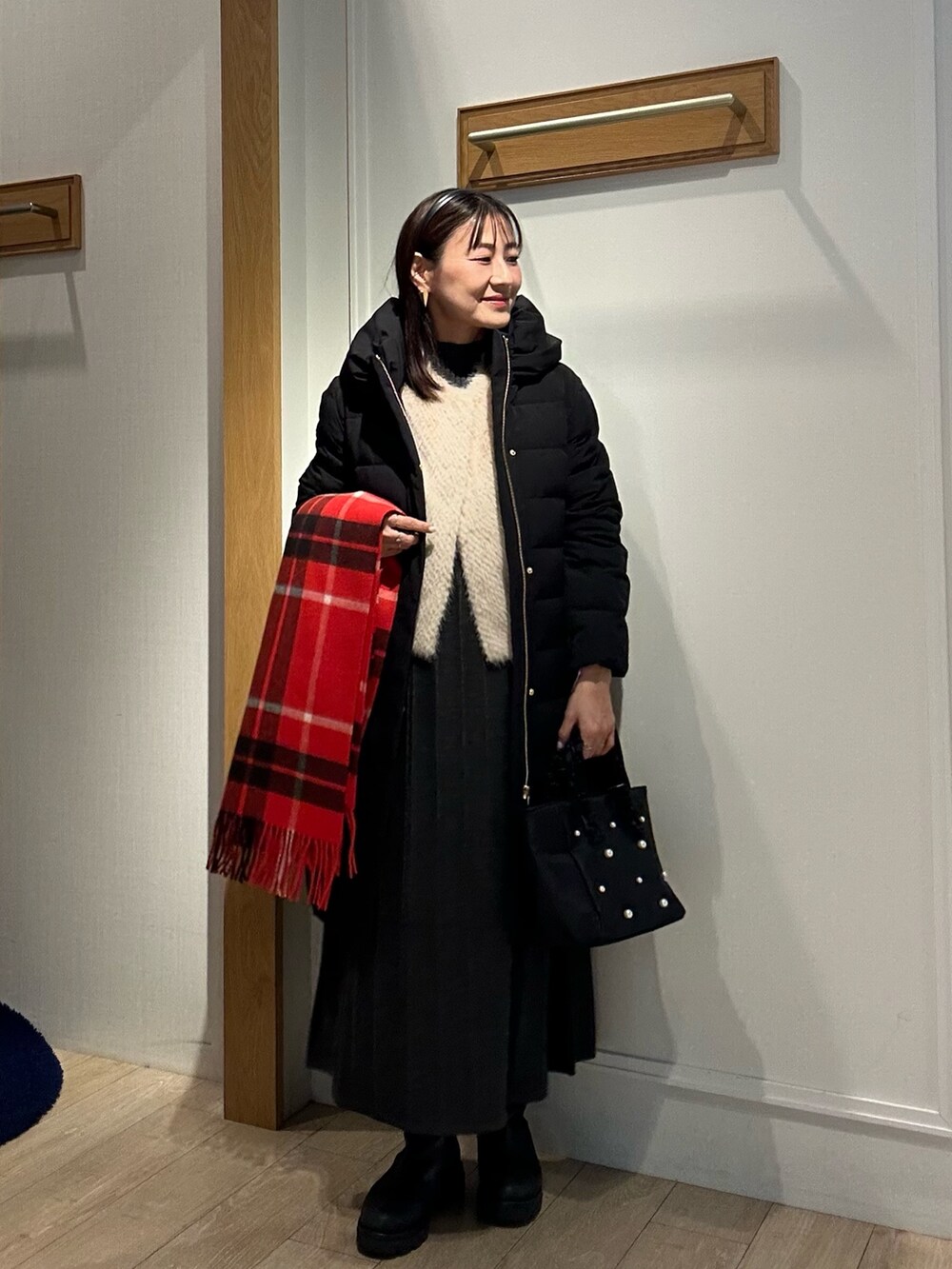グレー系のワンピース、ブラック系のダウンジャケット/コート、ベージュ系のブルゾンを着用したレディースの冬コーディネートの9枚目の写真