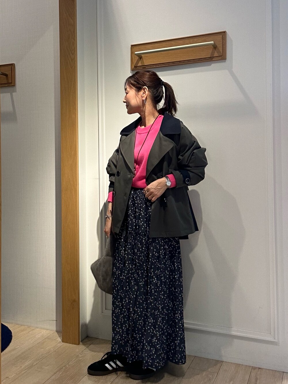 グレー系のトレンチコート、ピンク系のニット/セーターを着用したレディースの秋コーディネートの5枚目の写真