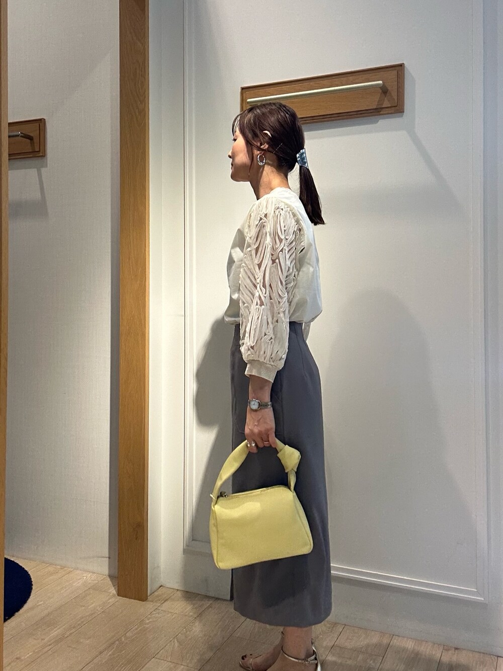 ホワイト系のTシャツ/カットソー、グレー系のスカート、イエロー系のショルダーバッグを着用したレディースの春コーディネートの3枚目の写真
