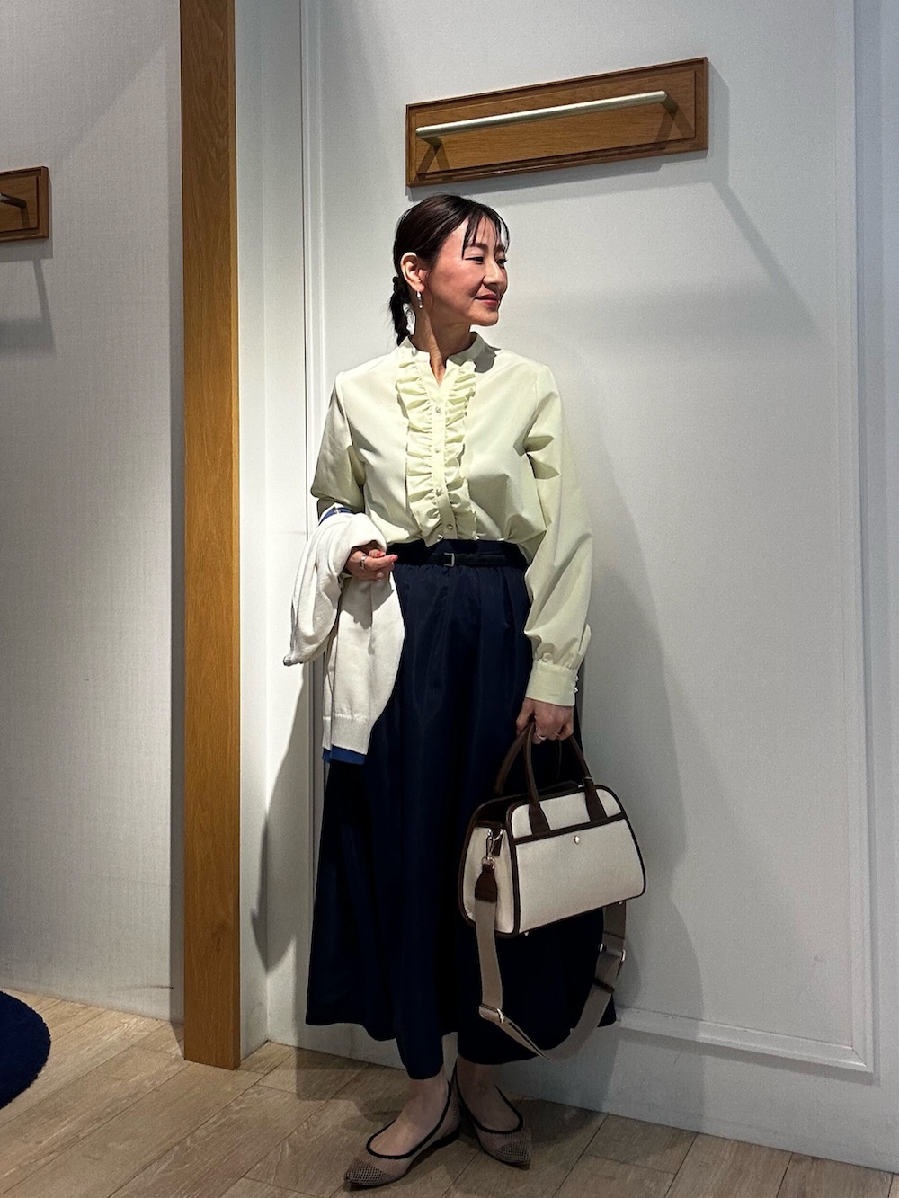 イエロー系のシャツ/ブラウス、ホワイト系のブルゾン、ブルー系のスカートを着用したレディースの冬コーディネートの9枚目の写真