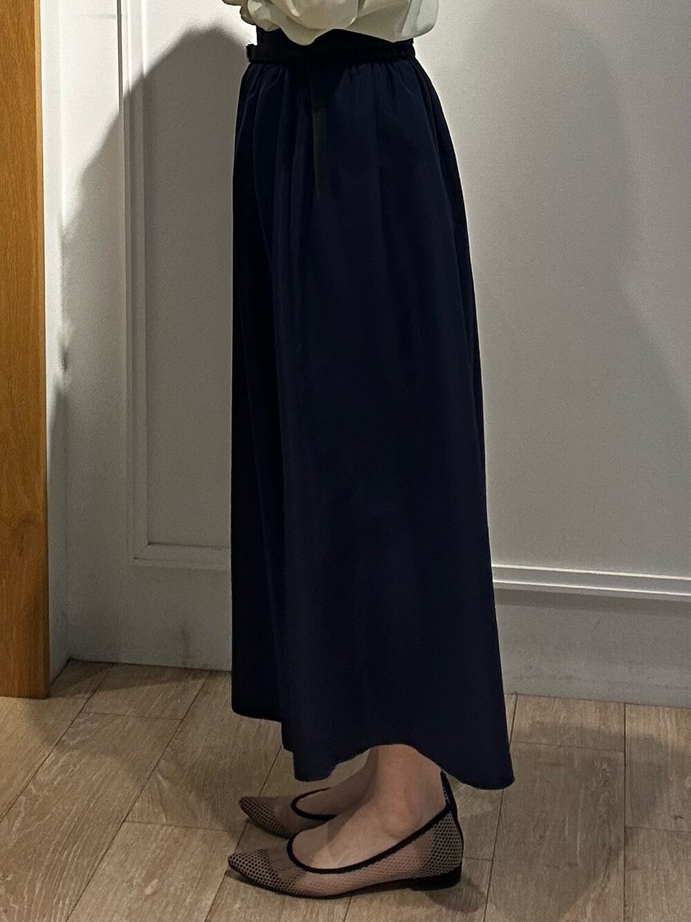 イエロー系のシャツ/ブラウス、ブルー系のスカート、ホワイト系のニット/セーターを着用したレディースの冬コーディネートの7枚目の写真