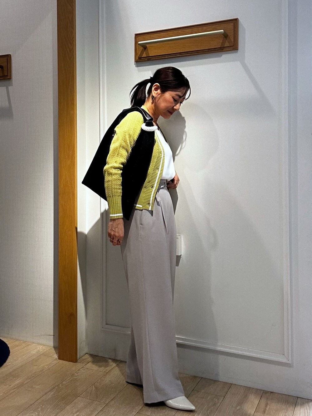 イエロー系のカーディガン/ボレロ、ホワイト系のTシャツ/カットソー、ベージュ系のその他パンツを着用したレディースの春コーディネートの2枚目の写真