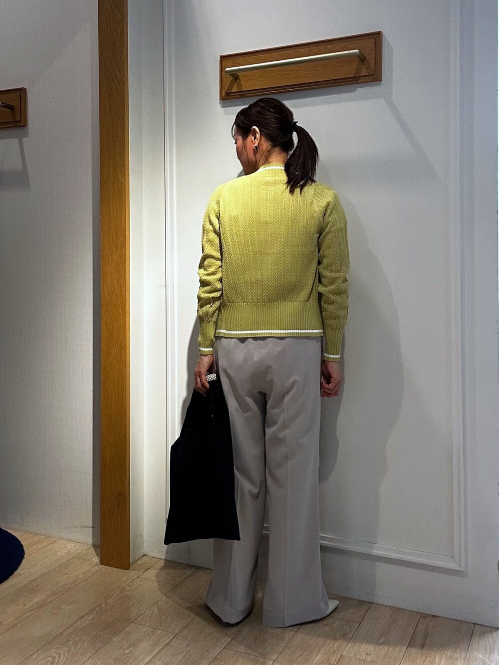 ベージュ系のその他パンツ、イエロー系のカーディガン/ボレロ、ブラック系のブルゾンを着用したレディースの春コーディネートの10枚目の写真