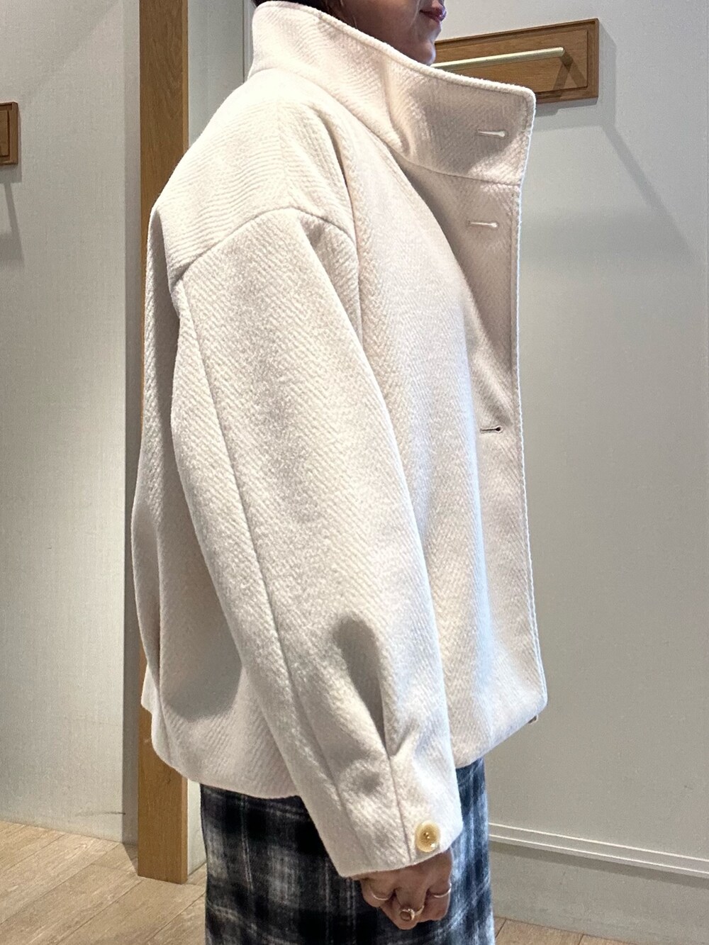 ホワイト系のトートバッグ、ホワイト系のテーラードジャケット、ブラック系のニット/セーターを着用したレディースの冬コーディネートの5枚目の写真