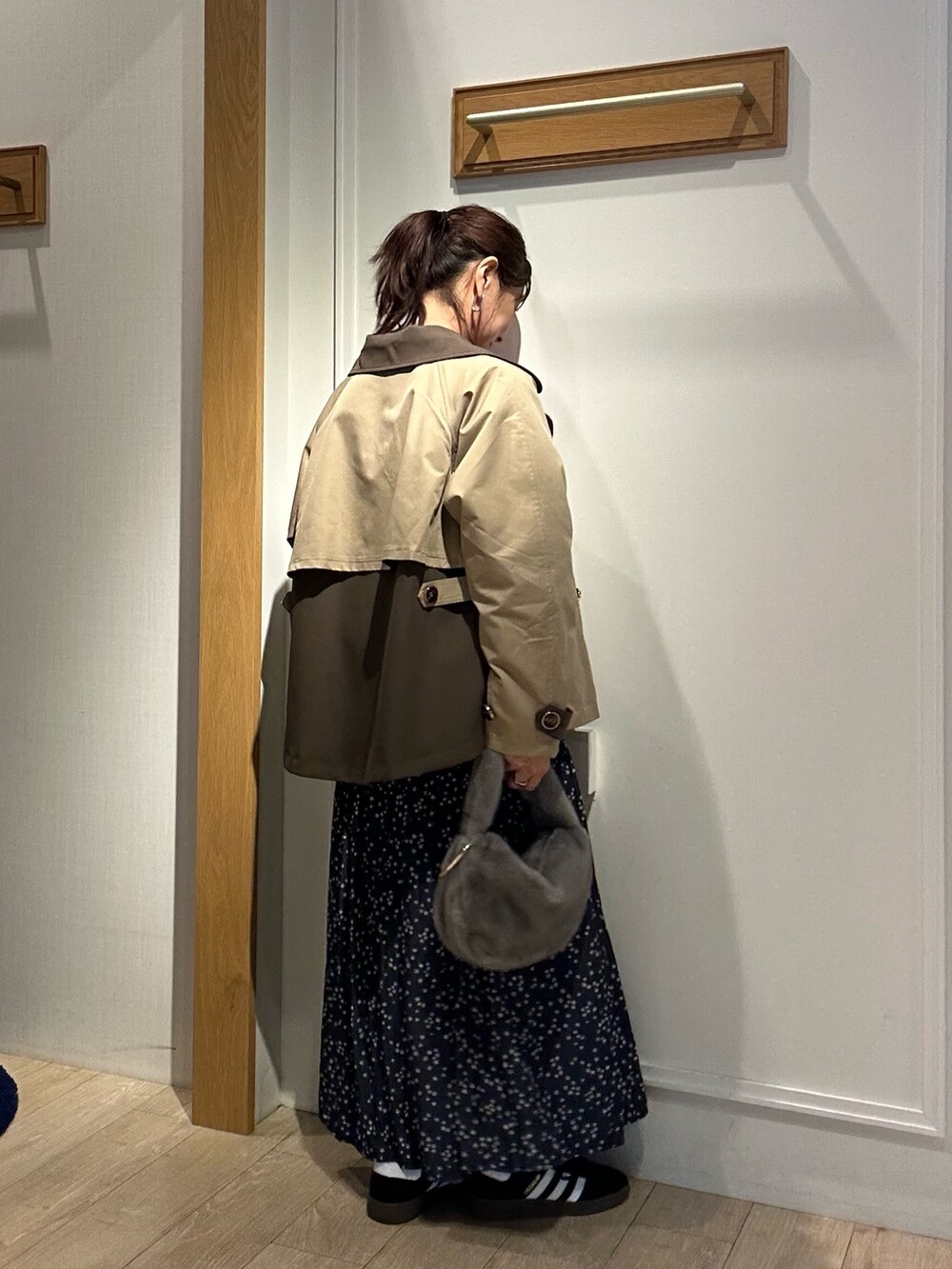 イエロー系のトレンチコート、ピンク系のニット/セーターを着用したレディースの秋コーディネートの6枚目の写真