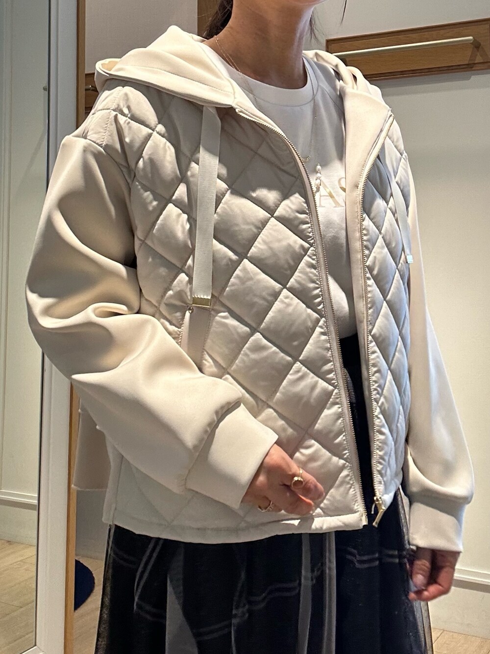 ホワイト系のTシャツ/カットソー、グレー系のスカート、ベージュ系のブルゾンを着用したレディースの冬コーディネートの8枚目の写真