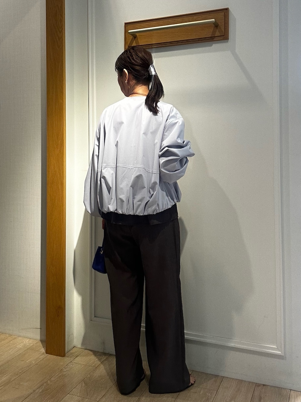 ブルー系のショルダーバッグ、ブルー系のブルゾン、グリーン系のシャツ/ブラウスを着用したレディースの春コーディネートの3枚目の写真