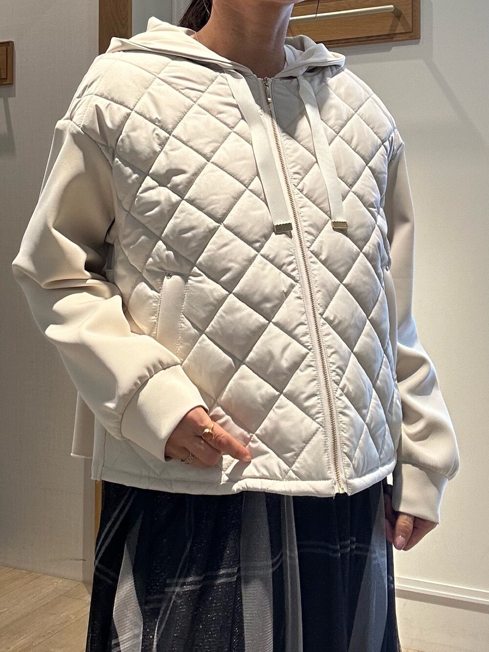 ホワイト系のTシャツ/カットソー、グレー系のスカート、ベージュ系のブルゾンを着用したレディースの冬コーディネートの6枚目の写真