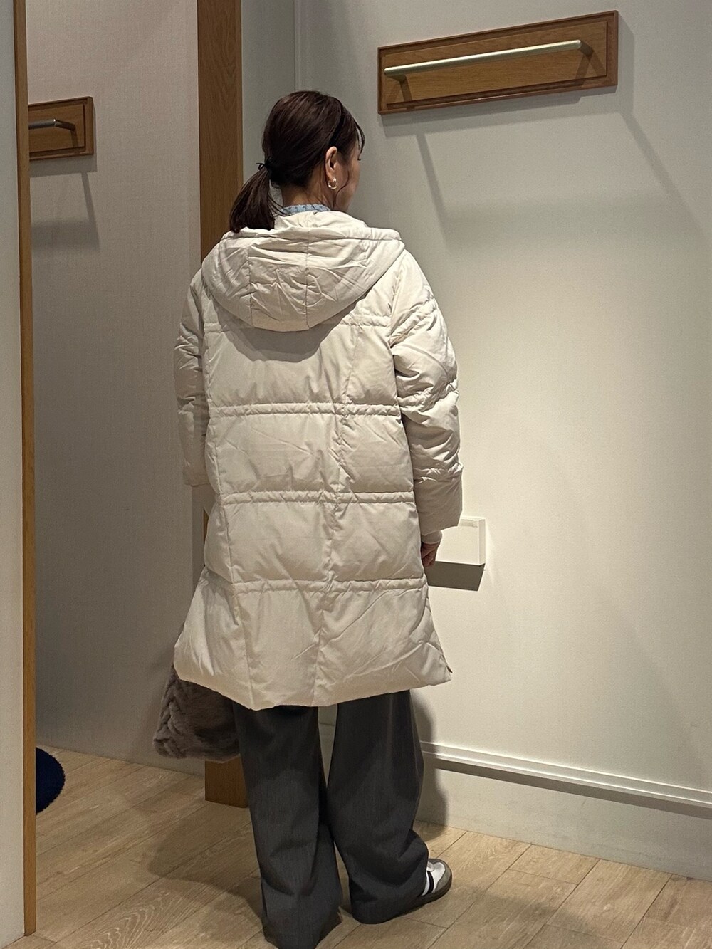 ベージュ系のダウンジャケット/コート、ブルー系のニット/セーターを着用したレディースの冬コーディネートの3枚目の写真